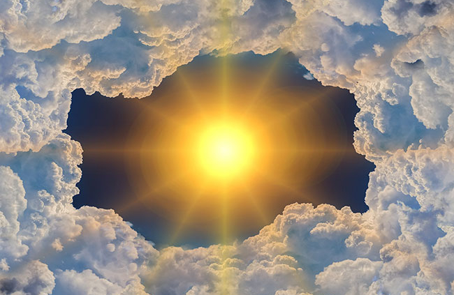 Shows a blazing hot sun against a black background and surrounded by a thick layer of clouds