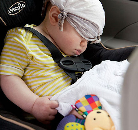 Shows an image of an infant sleeping in a car seat