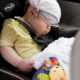 Shows an image of an infant sleeping in a car seat