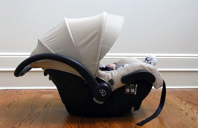 Shows an image of an infant car seat on the floor of a room in a house