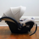 Shows an image of an infant car seat on the floor of a room in a house